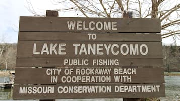 A wooden welcome sign for Lake Taneycomo, indicating public fishing and cooperation with the Missouri Conservation Department.