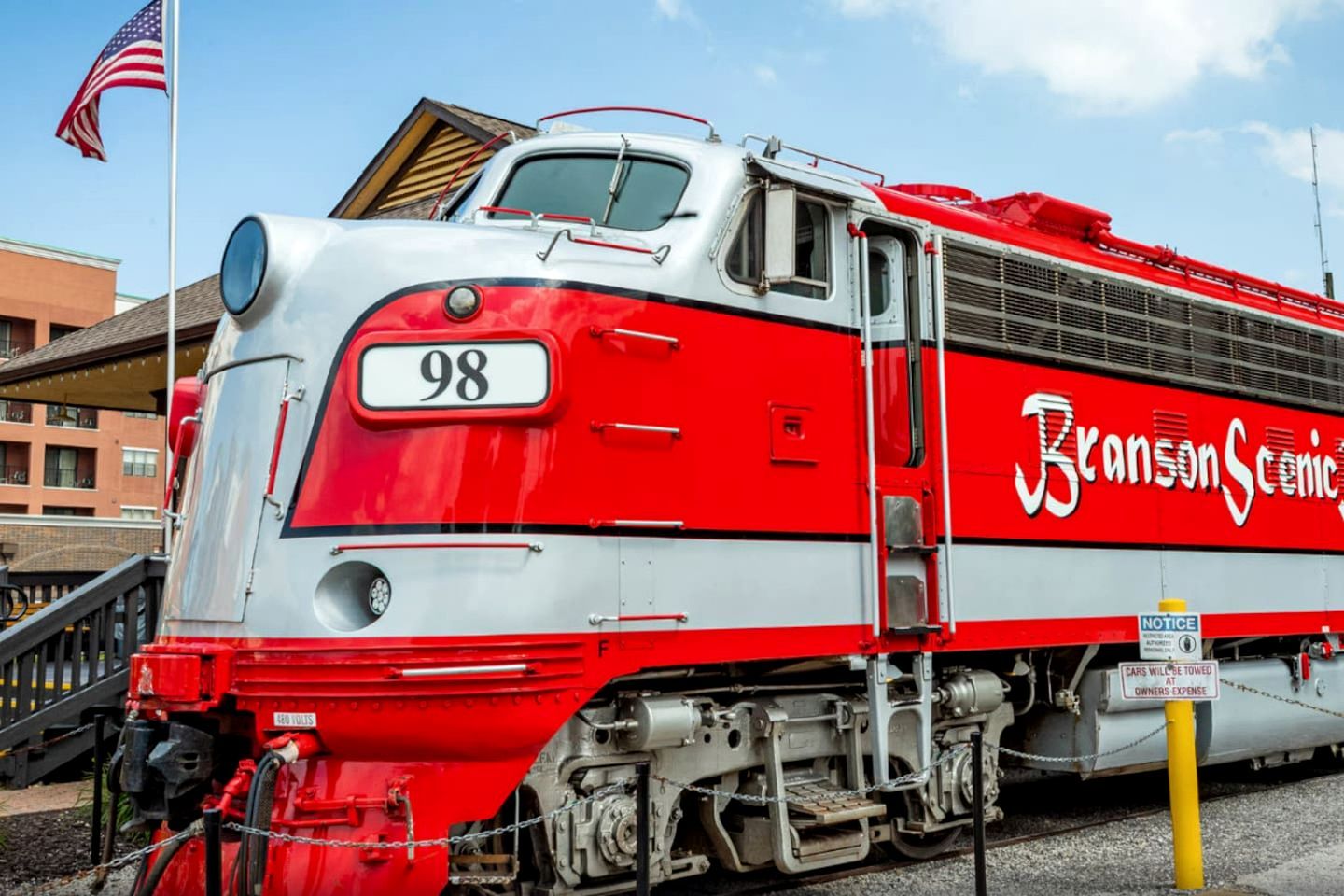 A red and white train with the number 98 and the name 'Branson Scenic' on its side.