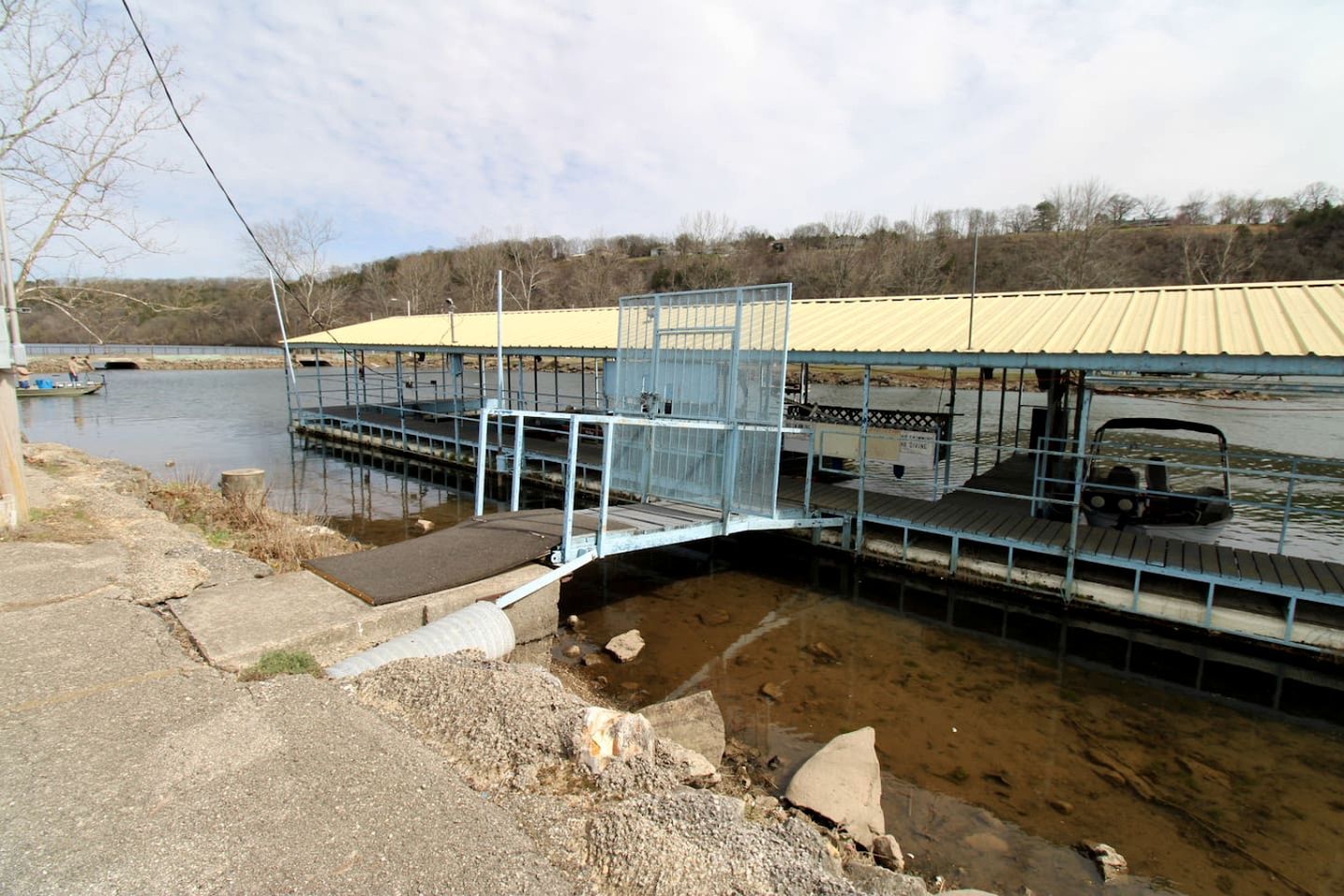 A bridge over a water body with a metal railing and a covered walkway.
