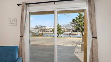 A room with a view of a waterfront, a bench, and a sign on the wall.