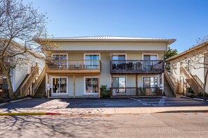 A two-story building with a central entrance, balconies on each floor, and a parking lot in front. - Three Bedroom Condo with Pool in North Ocean City (Ocean City)