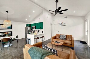 A modern living space with a kitchen, dining area, and seating area. - Modern Cabin for Four in Wimberley, Texas, for Glamping Escapes in Nature (Wimberley)