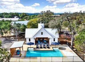 A large house with a swimming pool, outdoor seating, and a view of the surrounding landscape. - Stunning Three Cabins Great for Groups in Wimberley, Texas (Wimberley)
