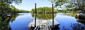 A calm river with a dock, surrounded by lush greenery and trees. - Cabin Getaway: Pet-Friendly Oasis on the Ochlockonee River Bend, Ideal for Fishing and Swimming (Wakulla County)