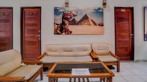 Un hall con un sofá, una mesa de centro y dos puertas indicadas con las letras 'D' y 'E'.