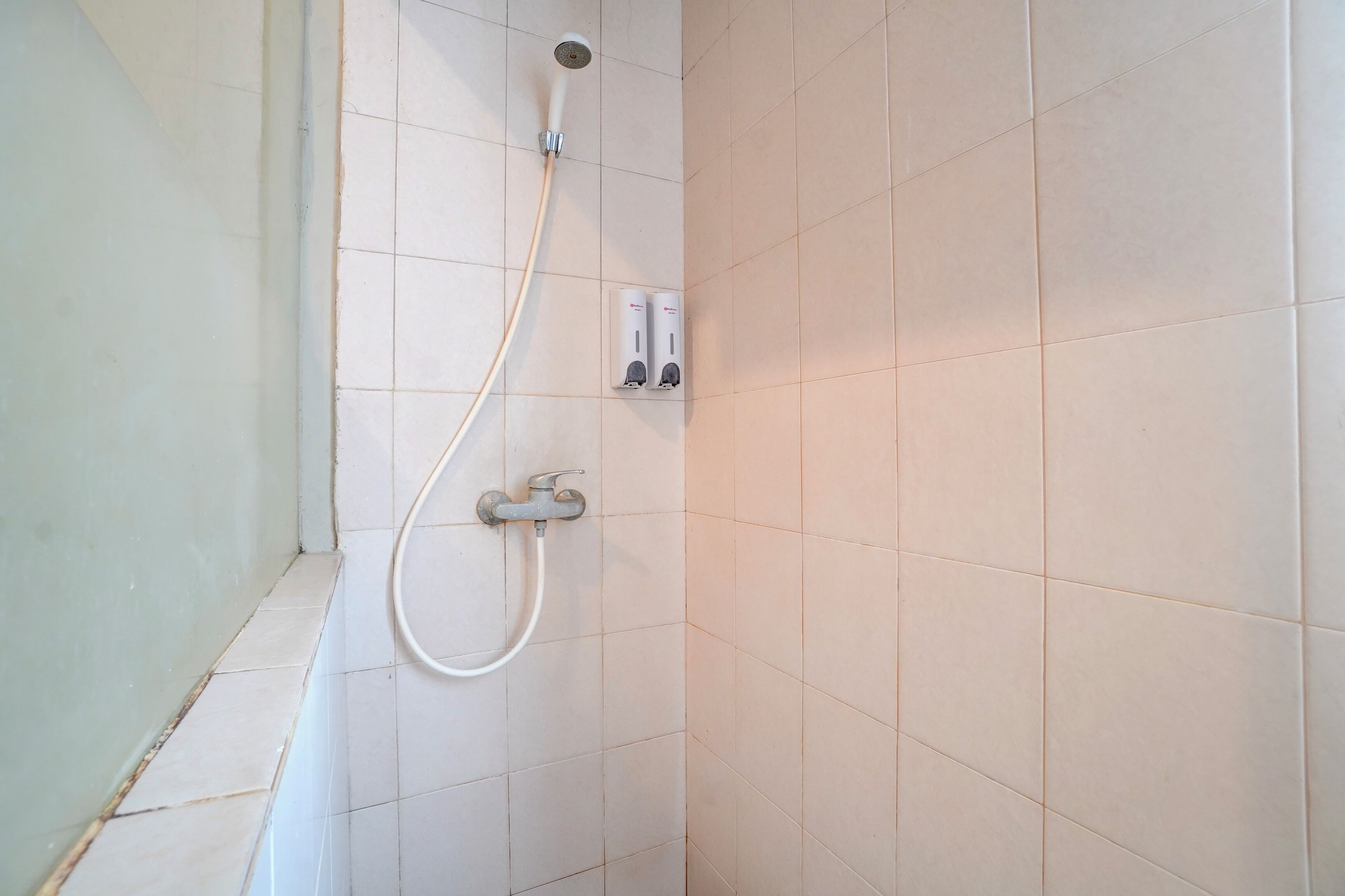 Ducha con manguera de mano y mandos empotrados.