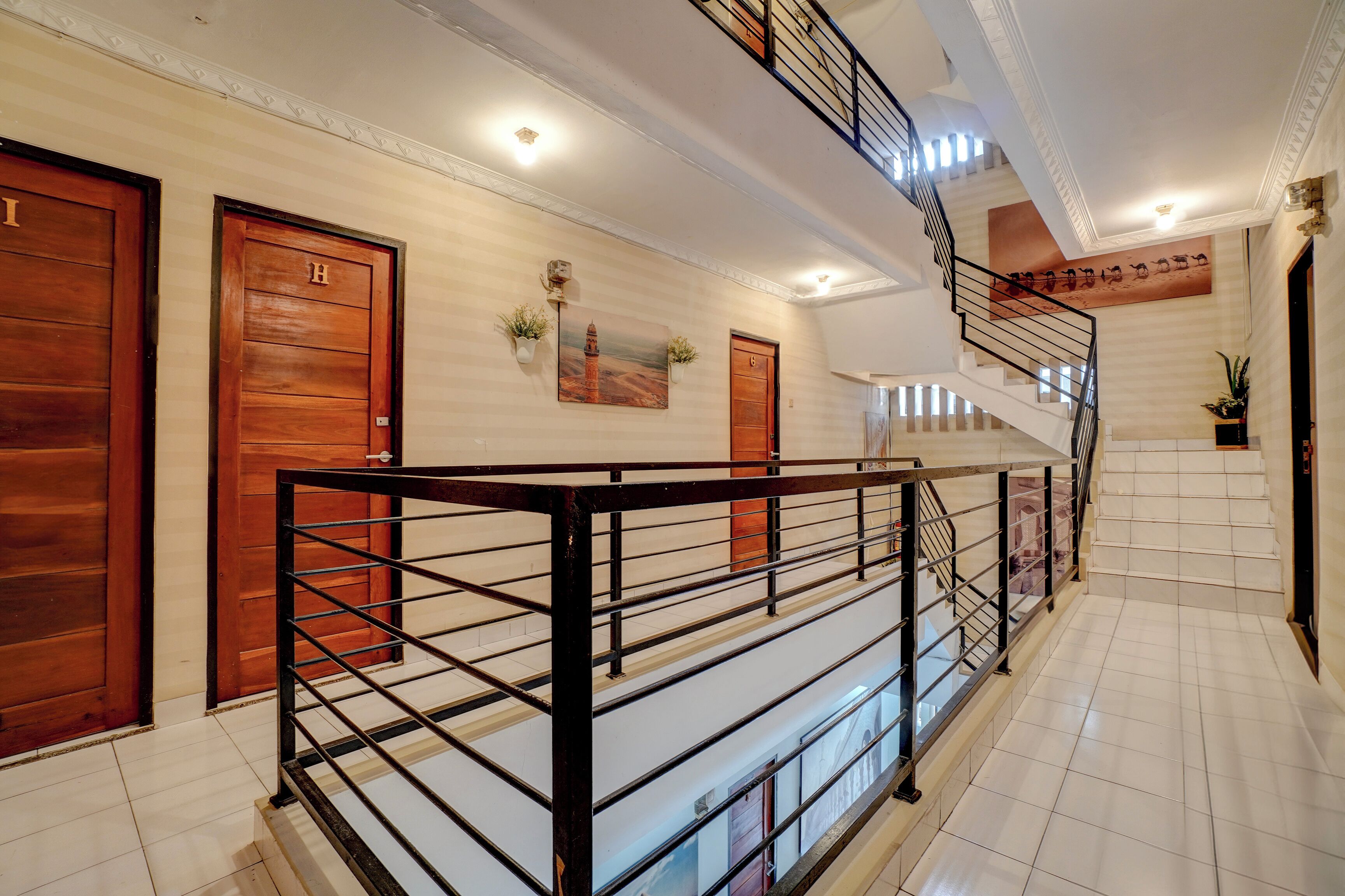Un vestíbulo de hotel con una escalera, puertas de madera y una pared decorativa.