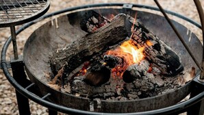 A metal fire pit with burning wood and embers. - Build Amazing New Memories at this Lovely Safari Tent in Branson, Missouri (Branson)
