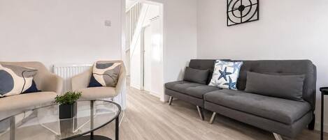 Un salon moderne avec deux canapés, une table basse en verre et un design minimaliste.