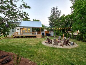 Une maison avec une terrasse, un foyer extérieur et des meubles de jardin.