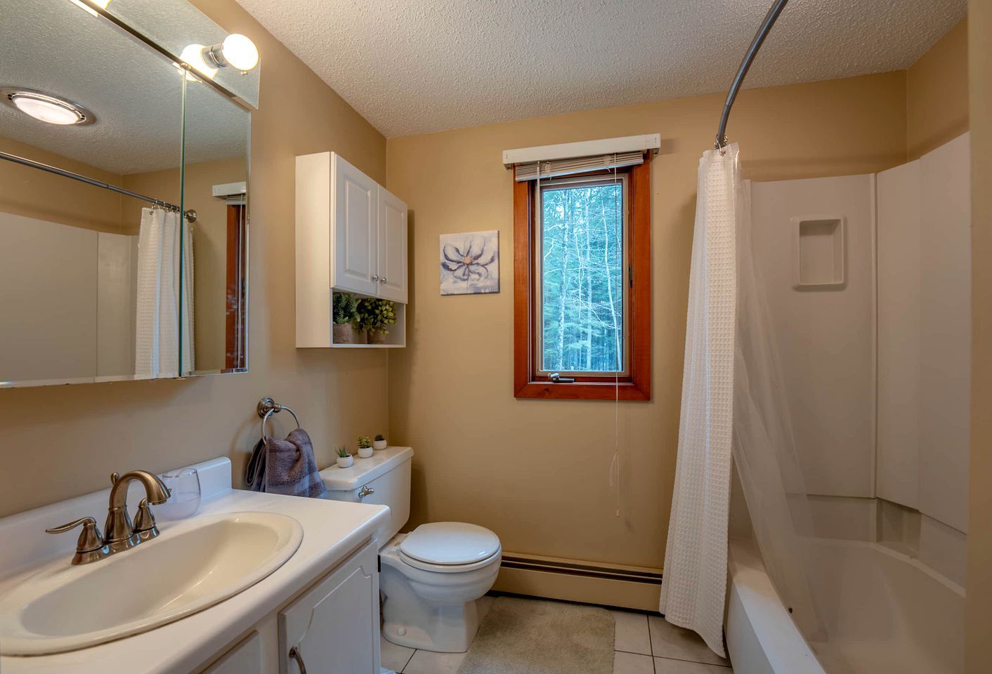 Une salle de bain avec un lavabo, des toilettes et une douche.