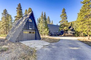 A wooden cabin with a garage, surrounded by trees and a clear sky. - Luxury A-Frame with Hot Tub for Dreamy Vacations in Colorado (Blue River)