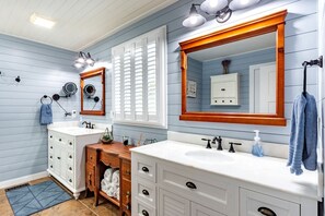 A bathroom with two sinks, wooden vanity, towel rack, and a mirror with a wooden frame. - Lynchburg's Best-Kept Secret: A Unique Rental with Private Dock and Open Water Views (Lynchburg)