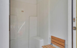 A bathroom with a shower, a toilet, and a bench. - Ultimate Glamping Adventure in Suches, Georgia with a Safari Tent Retreat (Suches)