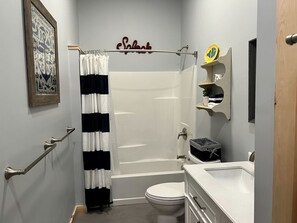 Une salle de bain avec douche, toilettes et lavabo.