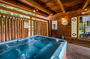 A wooden cabin with a hot tub, wooden walls, and a window with a view of the outdoors. - Gorgeous Secluded Wooden Cabin with Hot-tub and Pool Table in Sevierville, Tennessee (Sevierville)