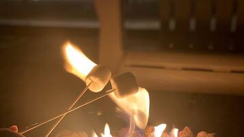 A campfire with marshmallows being roasted.
