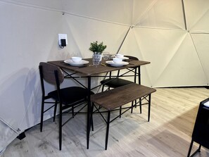 A tented dining area with a table set for four, including plates, bowls, and glasses. - Wonderful Cozy Dome with Barbecue and Fireplace in Kanab, Utah (Kanab)