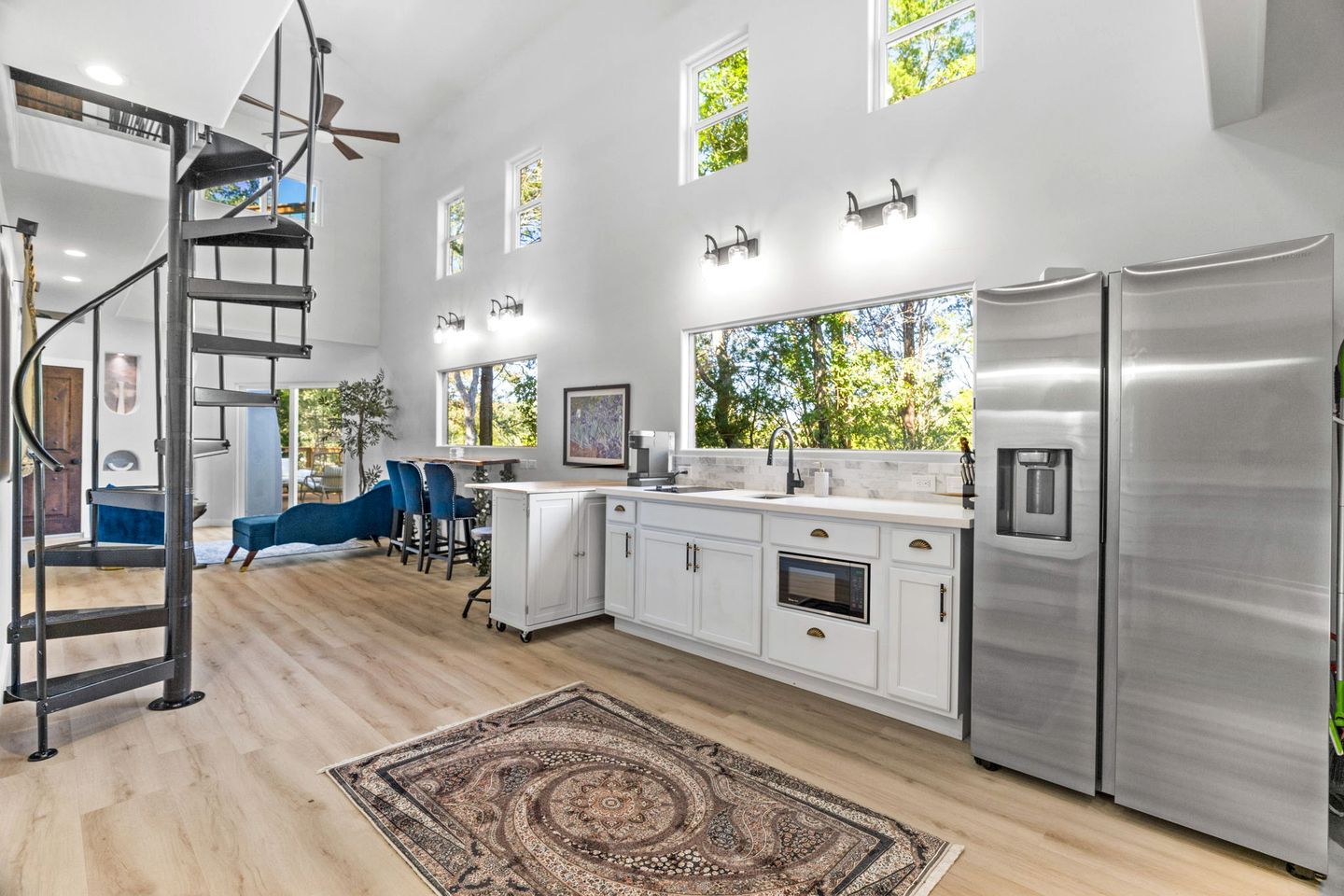 A modern kitchen with white cabinetry, stainless steel appliances, and a central island.