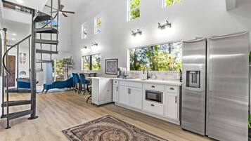 A modern kitchen with white cabinetry, stainless steel appliances, and a central island.
