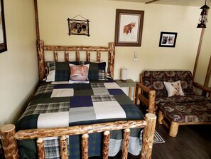Une chambre à coucher rustique avec un lit en bois, une chaise en bois et une table de chevet.