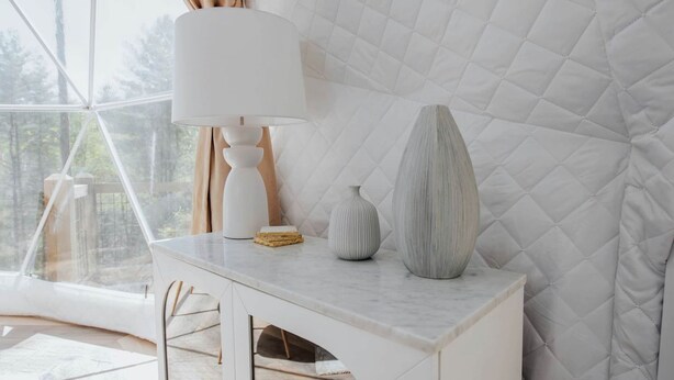 A modern room with a large window, a white table with a lamp, and two decorative vases. - Unmatched Views Await You at this Cherry Log, Georgia Designer Dome near Fall Branch Falls (Cherry Log)