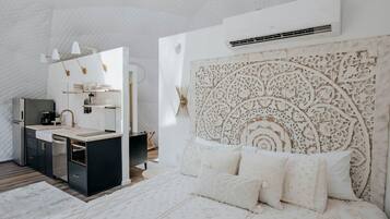 Et moderne soveværelse med en stor seng, et natbord og en indbygget garderobe.