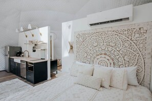 Une chambre moderne avec un grand lit, une table de chevet et une armoire intégrée.