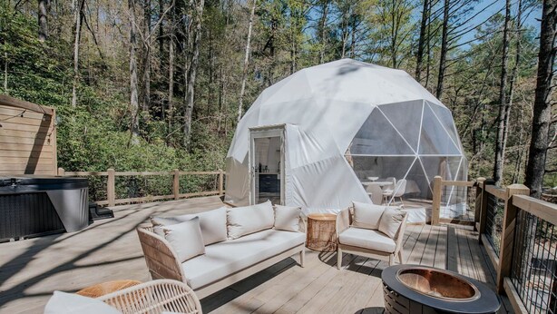 A geodesic dome tent with a wooden deck, outdoor furniture, and a hot tub. - Unmatched Views Await You at this Cherry Log, Georgia Designer Dome near Fall Branch Falls (Cherry Log)