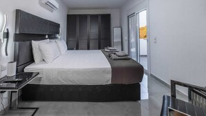 Een moderne slaapkamer met een bed, nachtkastje en uitzicht op het groen.