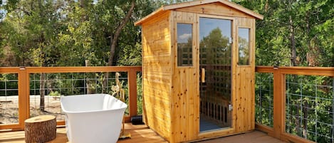 A wooden deck with a hot tub and a wooden cabin structure.