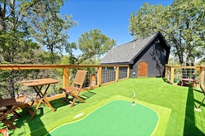 A house with a sloped roof, a fenced backyard, and a small lawn.