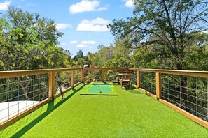 A miniature golf course with a wooden deck and a green artificial turf. - Outstanding Luxurious Dome with Mini Golf, Outdoor Bath, Sauna and Lake Views in Elgin, Texas (Elgin)