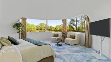 A bedroom with a bed, two sofas, a coffee table, and a TV.