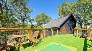 A house with a sloped roof, a fenced backyard, and a small lawn. - Outstanding Luxurious Dome with Mini Golf, Outdoor Bath, Sauna and Lake Views in Elgin, Texas (Elgin)