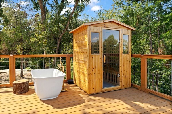 A wooden deck with a hot tub and a wooden cabin structure.