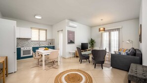 Un appartement moderne comprenant une cuisine, un coin repas et un salon.