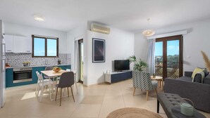 Een modern appartement met keuken, eetgedeelte, woonkamer en balkon.