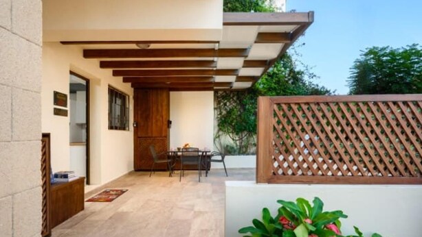 A patio with a table and chairs, a wooden door, and a wooden fence. - Rodini Anassa | Dimitra, Apartment (Rodos)