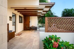 Un patio con una mesa y sillas, una puerta de madera y una cerca de madera.