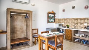 A compact kitchen with a dining area, a built-in oven, and a microwave. - Summer Paradise Stegna (RODOS)