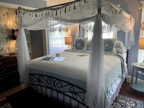 A four-poster canopy bed with a quilted bedspread, bedside lamps, and a nightstand with a lamp. - Incredible Cottage with Hot-tub in Penn Yan, New York (Penn Yan)