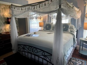 A four-poster canopy bed with a quilted bedspread, bedside lamps, and a nightstand with a lamp. - Incredible Cottage with Hot-tub in Penn Yan, New York (Penn Yan)
