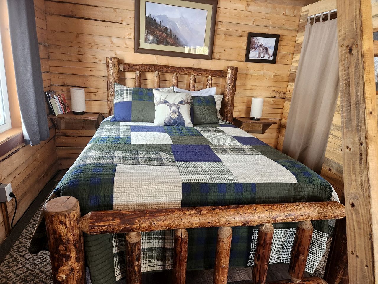 Quarto de cabana de madeira com cama, almofadas e colcha.
