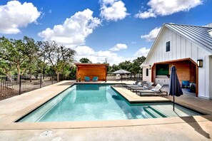 Una piscina con sillas de descanso y una estructura de madera.