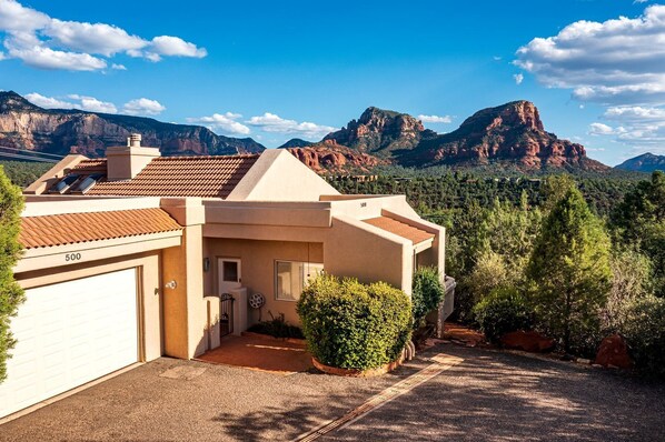 A single-story house with a garage, a small front porch, and a view of mountains. - Spectacular Rental with Breathtaking Mountain Views in Arizona (Sedona)