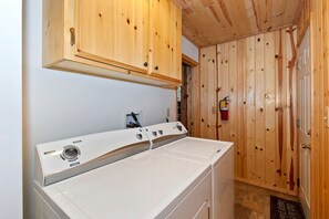 Ein Waschraum mit Holzausstattung, einer Waschmaschine und einem Trockner.