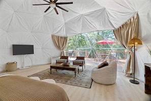 A tented room with a television, seating area, and a view of the outdoors.