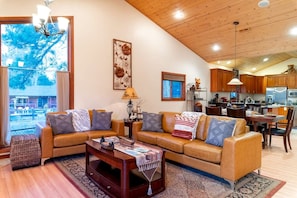 A spacious living area with a sofa set, a coffee table, and a view of the outdoors. - Experience Bliss: Big Bear Lake Rental with Exclusive Hot Tub (Big Bear Lake)
