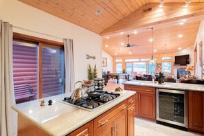 A spacious kitchen with a stove, a dining area with a pool table, and a view of the outdoors. - Experience Bliss: Big Bear Lake Rental with Exclusive Hot Tub (Big Bear Lake)